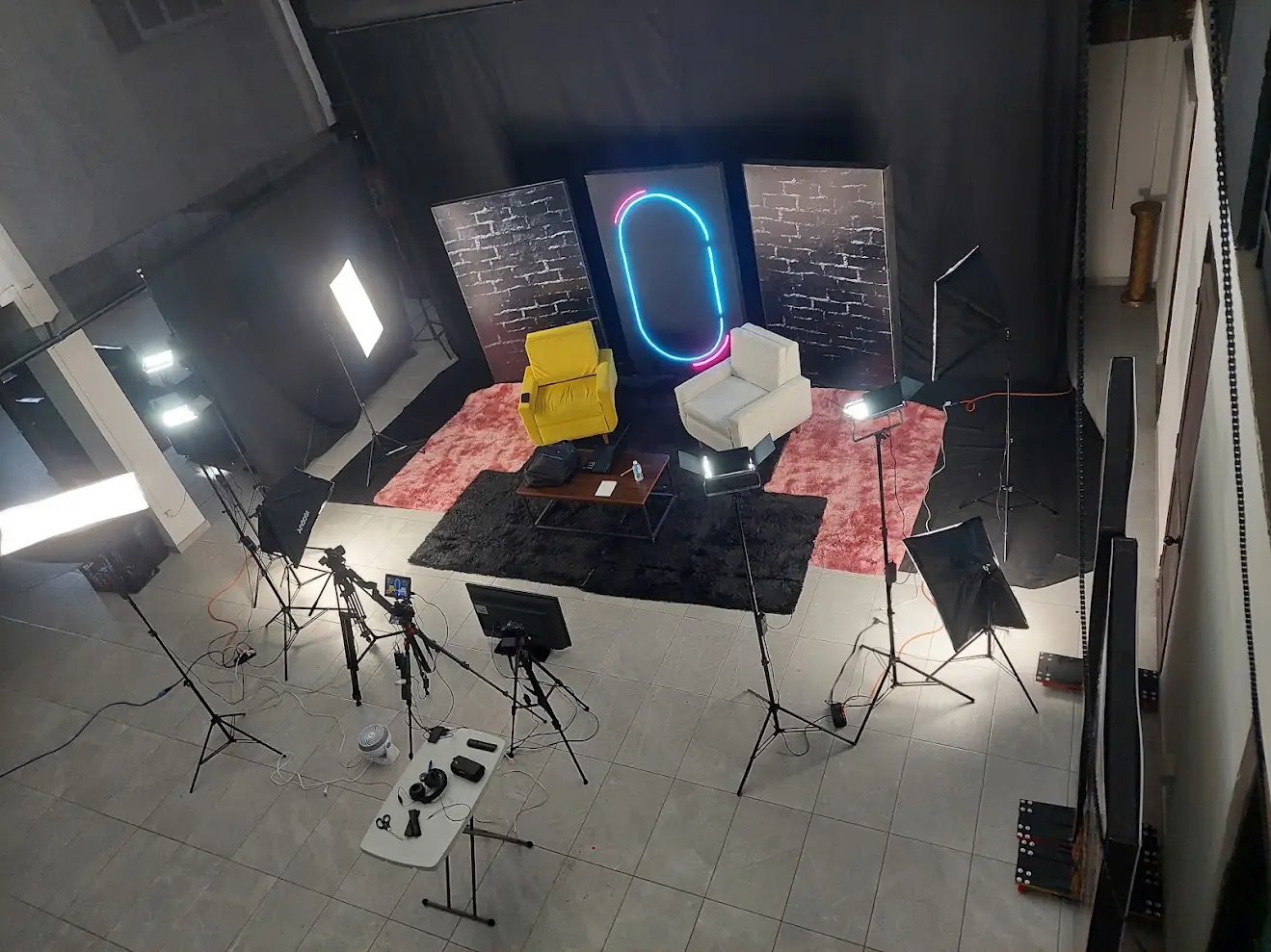 Vista aérea del estudio de grabación en renta para podcast en Durango, con set de ladrillo, neón, luces y cámaras